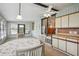 Bright sunroom dining area featuring a ceiling fan, large windows and adjacent kitchen at 5451 Antigua Dr, Zephyrhills, FL 33541