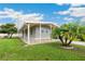 Well-maintained single-story house with a wide covered patio, neat landscaping, and mature trees at 5451 Antigua Dr, Zephyrhills, FL 33541