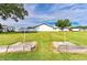 Outdoor horseshoe pit area surrounded by a lush green lawn and community buildings for friendly games at 5451 Antigua Dr, Zephyrhills, FL 33541