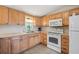 Functional kitchen featuring light wood cabinets, neutral countertops, and modern appliances at 5451 Antigua Dr, Zephyrhills, FL 33541