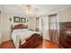 Bright bedroom featuring hardwood floors, a ceiling fan, and decorative curtains at 5451 Antigua Dr, Zephyrhills, FL 33541