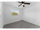 Sunny bedroom features a ceiling fan, bright window, and modern tile flooring at 546 90Th N Ave, St Petersburg, FL 33702