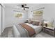 Brightly lit bedroom features a ceiling fan, two windows, and comfortable furniture at 546 90Th N Ave, St Petersburg, FL 33702