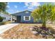 Charming blue home with a well-manicured yard and covered entrance at 546 90Th N Ave, St Petersburg, FL 33702