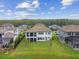 Aerial view of a home with large lawn and tile roof, surrounded by lush landscaping at 6129 Marsh Trail Dr, Odessa, FL 33556