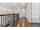 Upstairs hallway with wood floors and a dark railing at 6129 Marsh Trail Dr, Odessa, FL 33556