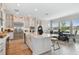 Modern kitchen features stainless steel appliances, white cabinetry, and large island with breakfast bar at 6129 Marsh Trail Dr, Odessa, FL 33556