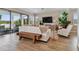 Bright living room with lake views, modern furniture, and wood-look tile flooring at 6129 Marsh Trail Dr, Odessa, FL 33556