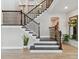 Elegant staircase with dark wood and white risers, complemented by decorative plants and mirrors at 6129 Marsh Trail Dr, Odessa, FL 33556