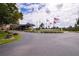 Welcoming community center with manicured landscaping, American flags, and a well maintained entrance at 624 La Jolla Ave, Sun City Center, FL 33573