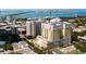 An aerial shot captures a high-rise building surrounded by water, trees and city at 628 Cleveland St # 711, Clearwater, FL 33755