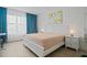 Bright bedroom featuring herringbone floors, soft lighting, and stylish blue curtains at 628 Cleveland St # 711, Clearwater, FL 33755