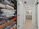 Organized walk-in closet with shelving, and a view of the hallway leading to the bathroom at 628 Cleveland St # 711, Clearwater, FL 33755