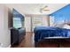 This main bedroom features a large TV, hardwood floors, two windows, and neutral and blue walls at 6324 35Th Avenue E Cir, Palmetto, FL 34221