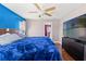 Bright main bedroom featuring a ceiling fan, hardwood floors, a large TV, and access to the ensuite bathroom at 6324 35Th Avenue E Cir, Palmetto, FL 34221