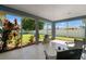 Back view of the screened-in porch complete with furniture, a grill, and views of the fenced in backyard at 6324 35Th Avenue E Cir, Palmetto, FL 34221
