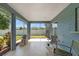 View of the screened-in porch complete with furniture, a grill, and views of the backyard and lawn at 6324 35Th Avenue E Cir, Palmetto, FL 34221