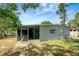 Backyard shows screened patio, lush grass, mature trees and access to the side of the home at 6601 13Th N St, St Petersburg, FL 33702
