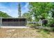 Exterior view of screened in patio and storage shed with partially fenced yard and shade trees at 6601 13Th N St, St Petersburg, FL 33702