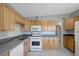 Kitchen with wooden cabinets, stainless steel sink, and white appliances at 6601 13Th N St, St Petersburg, FL 33702