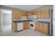 Kitchen featuring wooden cabinets, white appliances, and tile flooring at 6601 13Th N St, St Petersburg, FL 33702