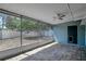Enclosed patio features stone tile flooring, white trim, access to back door and scenic views of fenced yard at 6601 13Th N St, St Petersburg, FL 33702