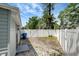 The side yard features a vinyl fence, gate, some gravel and access to the home, providing functionality and security at 6601 13Th N St, St Petersburg, FL 33702