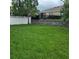 Green backyard with a fence and retaining wall at 7563 Ashcroft Dr, Wesley Chapel, FL 33545