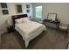 Bright bedroom with matching bedside lamps, sleek black desk and chair, and neutral toned walls and carpet at 7563 Ashcroft Dr, Wesley Chapel, FL 33545