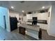 Bright kitchen with white cabinets, a gray island, and a view of the adjacent living spaces at 7563 Ashcroft Dr, Wesley Chapel, FL 33545