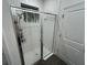 Modern shower with glass door, white tile surround and convenient towel hooks at 7563 Ashcroft Dr, Wesley Chapel, FL 33545