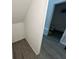 A small, unfinished storage area adjacent to a bathroom with gray wood look flooring at 7563 Ashcroft Dr, Wesley Chapel, FL 33545