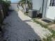 A narrow side yard covered in crushed shells, with a white door leading into the home at 7800 125Th St, Seminole, FL 33772