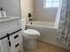A lovely bathroom featuring a white vanity, a white toilet, and a bathtub with tan tile surround at 7800 125Th St, Seminole, FL 33772