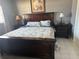 A traditionally styled bedroom features a wooden bed frame, matching end tables and a relaxing beach painting at 7800 125Th St, Seminole, FL 33772