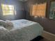 A comfy bedroom featuring a large window, blue comforter and gray walls at 7800 125Th St, Seminole, FL 33772