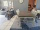 A dining room with a white wooden table and four chairs, with living room in background at 7800 125Th St, Seminole, FL 33772