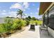 A backyard with a patio featuring seating and a firepit surrounded by lush green landscaping at 7923 Radcliffe Cir, Port Richey, FL 34668