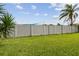 Well-maintained backyard with green lawn, privacy fence, and lush tropical landscaping at 7923 Radcliffe Cir, Port Richey, FL 34668