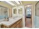 Bathroom with a marble countertop, wood cabinets, and pass through to the bedroom at 7923 Radcliffe Cir, Port Richey, FL 34668