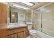 Cozy bathroom featuring a skylight, frosted glass shower doors, and ample vanity space at 7923 Radcliffe Cir, Port Richey, FL 34668