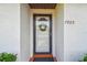 Close-up of a white front door with glass panel, decorative wreath, and the house number 7923 at 7923 Radcliffe Cir, Port Richey, FL 34668
