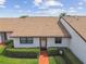 Charming condo with a well-kept lawn and manicured bushes in front at 7923 Radcliffe Cir, Port Richey, FL 34668