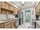 Spacious kitchen boasting stainless steel appliances, wood cabinetry, and utility room access at 7923 Radcliffe Cir, Port Richey, FL 34668