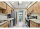 Full kitchen view featuring stainless steel appliances, wood cabinets and utility area at 7923 Radcliffe Cir, Port Richey, FL 34668