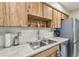 Classic kitchen featuring wood cabinets, stainless steel sink, and modern appliances at 7923 Radcliffe Cir, Port Richey, FL 34668