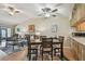 Comfortable living area featuring wood-look floors, a ceiling fan, and a cozy seating arrangement with a view into the kitchen at 7923 Radcliffe Cir, Port Richey, FL 34668