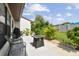 Back patio features a cozy seating area, an outdoor firepit and lush landscaping at 7923 Radcliffe Cir, Port Richey, FL 34668