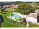 Aerial view of a sparkling community pool surrounded by lush landscaping and lounge chairs at 7923 Radcliffe Cir, Port Richey, FL 34668