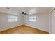 Cozy bedroom with neutral walls, wood floors, a ceiling fan, and natural light from the windows at 9218 Memorial Hwy, Tampa, FL 33615